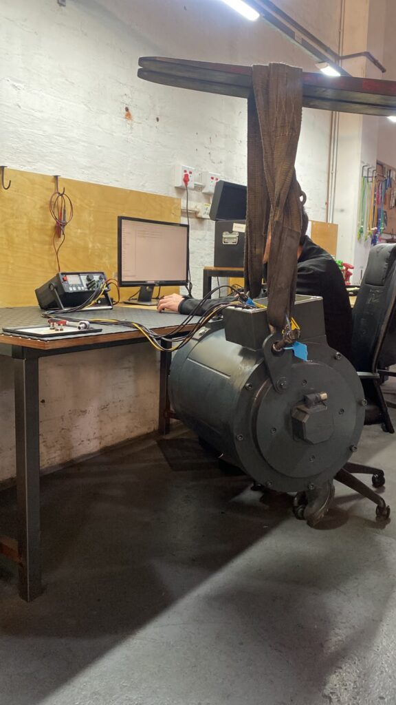 Servo motor suspended from a lifting strap during testing